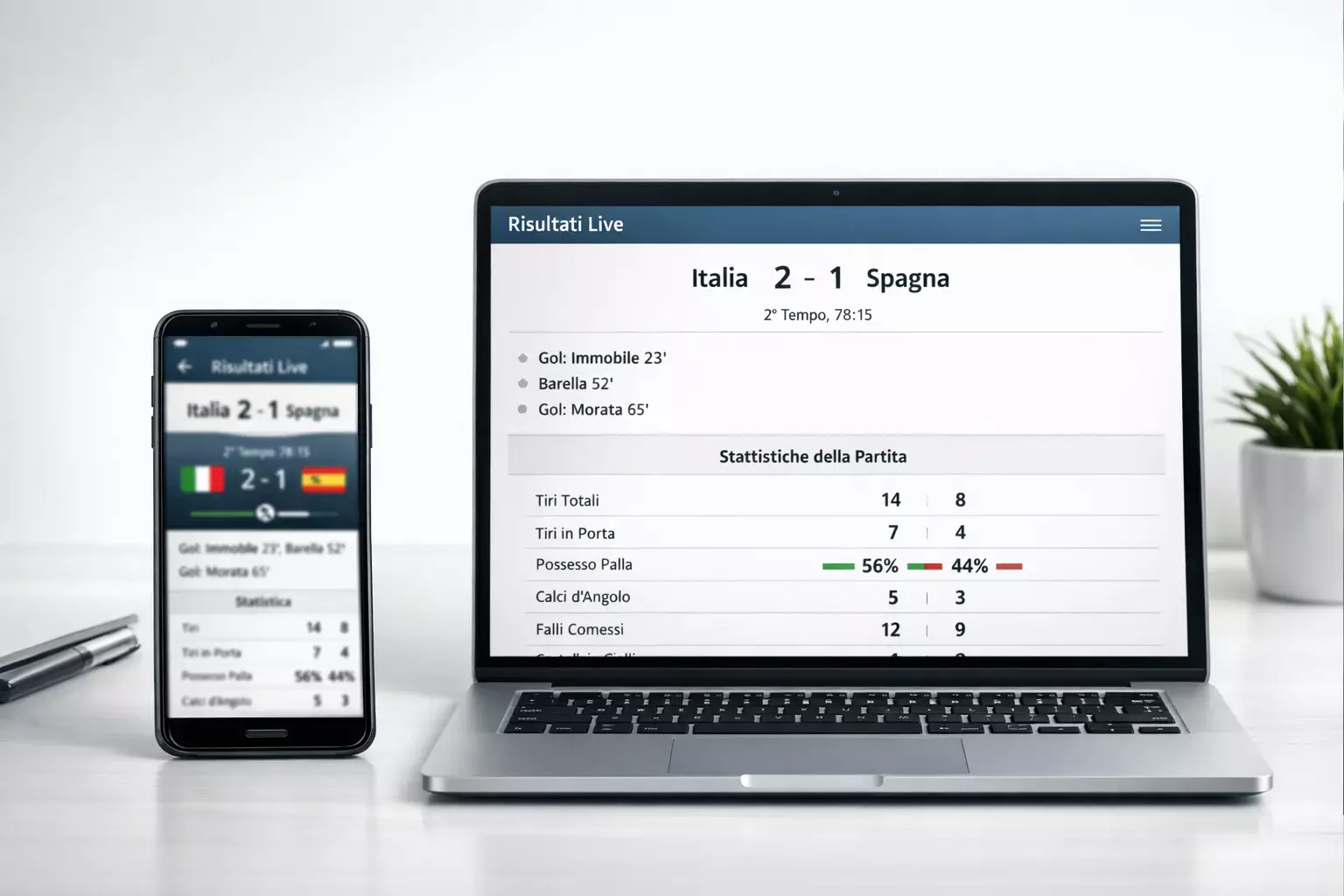 Smartphone con app di statistiche calcio aperta accanto a laptop